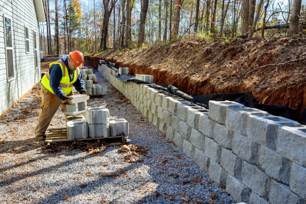 Residential retaining wall and shoring system designed to prevent slope failure and manage drainage runoff.