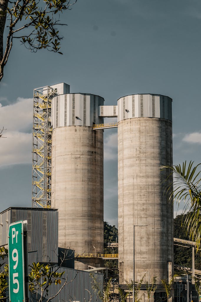 Vertical shot of silos at a cement plant in Colombia with industrial landscape.